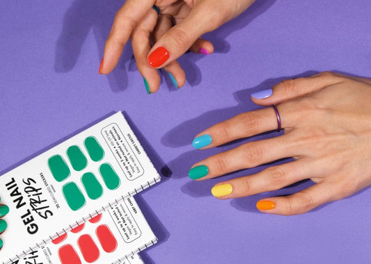 Colourful gel nail strips manicured being cured under UV/LED lamp
