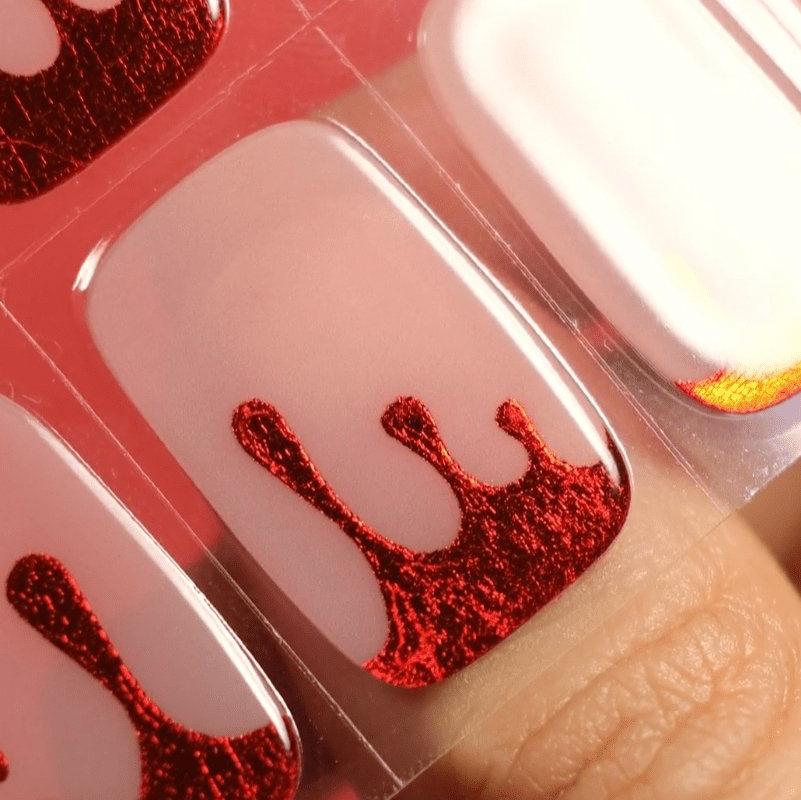 Gel nail sticker for Halloween using red gel polish on top of pearl background
