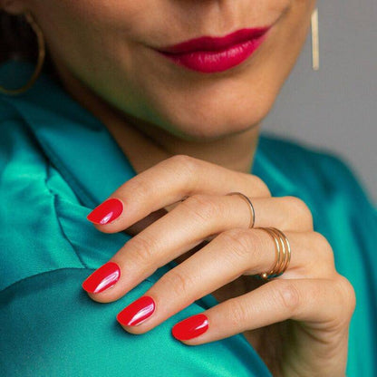 Glossy red manicure styled with jewelry.