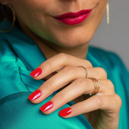 Glossy red manicure styled with jewelry.